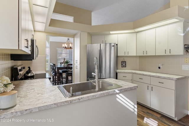 kitchen featuring stainless steel fridge, dark hardwood / wood-style flooring, white cabinets, a textured ceiling, and black electric range