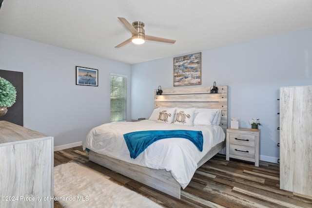 bedroom with dark hardwood / wood-style floors and ceiling fan