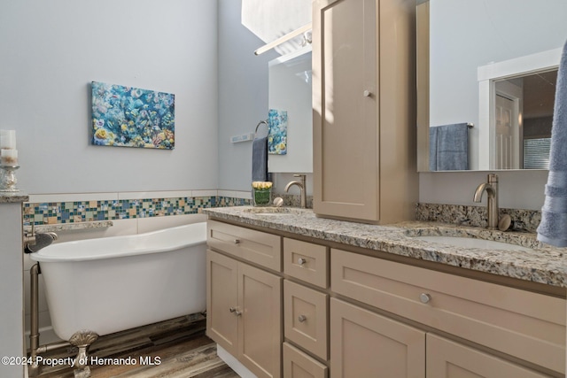 bathroom with hardwood / wood-style floors, vanity, tile walls, and a bathing tub