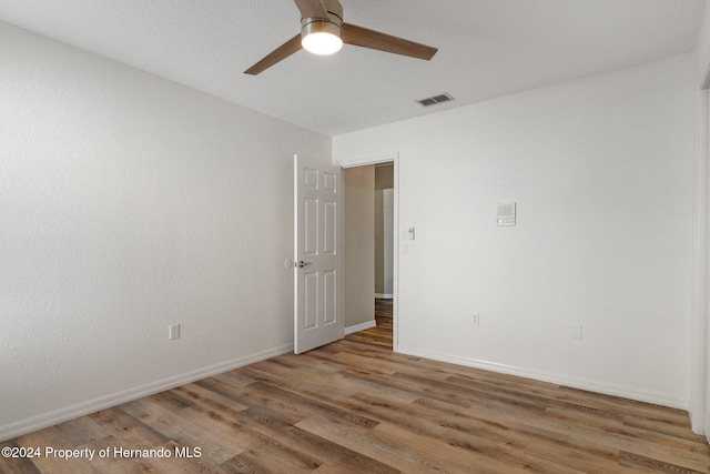 unfurnished room with ceiling fan and hardwood / wood-style floors