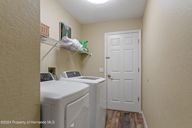 washroom featuring a textured ceiling, washing machine and dryer, and dark wood-type flooring