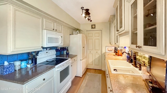 kitchen with white appliances, light hardwood / wood-style floors, lofted ceiling, and sink