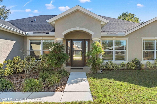 property entrance featuring a lawn