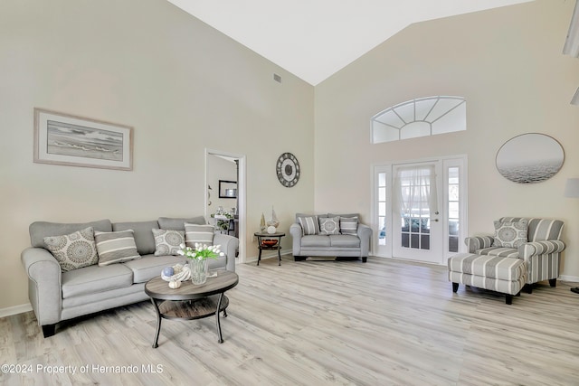 living room with high vaulted ceiling and light wood-type flooring