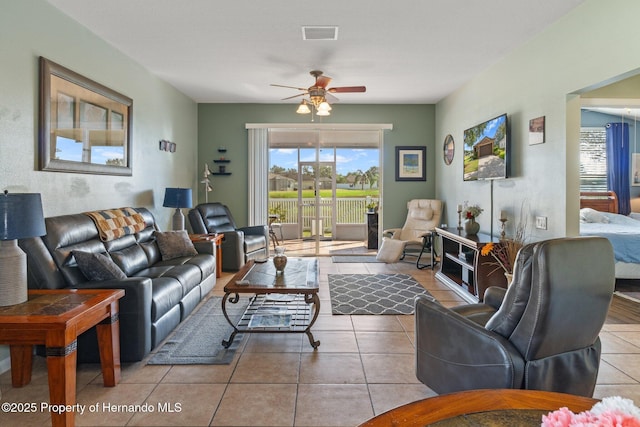 tiled living room with ceiling fan