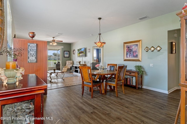 dining room with dark hardwood / wood-style flooring and ceiling fan