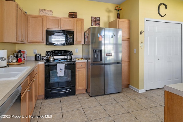 kitchen featuring sink, light tile patterned floors, and black appliances