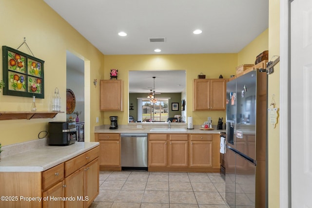 kitchen with pendant lighting, sink, light tile patterned floors, appliances with stainless steel finishes, and kitchen peninsula