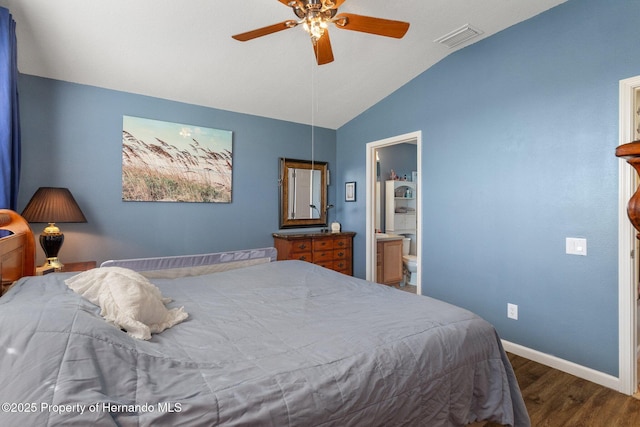 bedroom featuring ceiling fan, ensuite bath, dark hardwood / wood-style floors, and vaulted ceiling