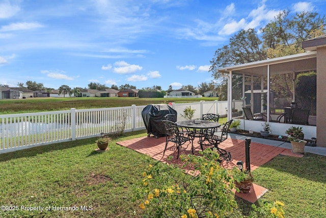 view of yard featuring a patio area, a sunroom, and a water view