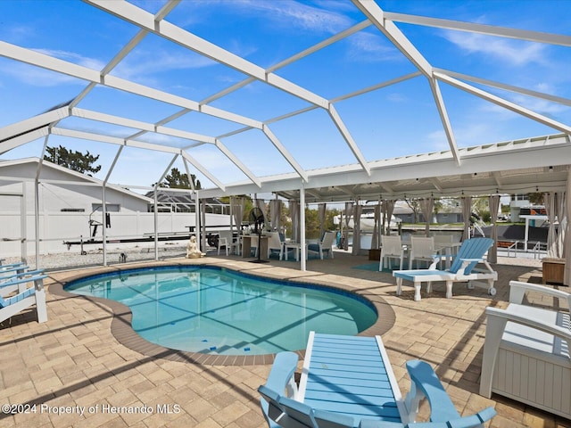 view of pool with a patio and glass enclosure