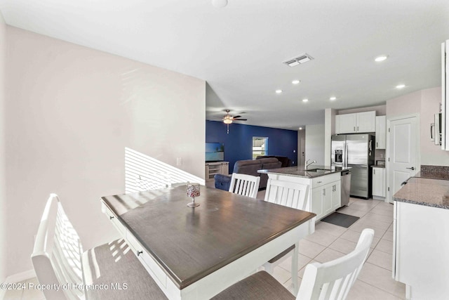 tiled dining area featuring ceiling fan and sink