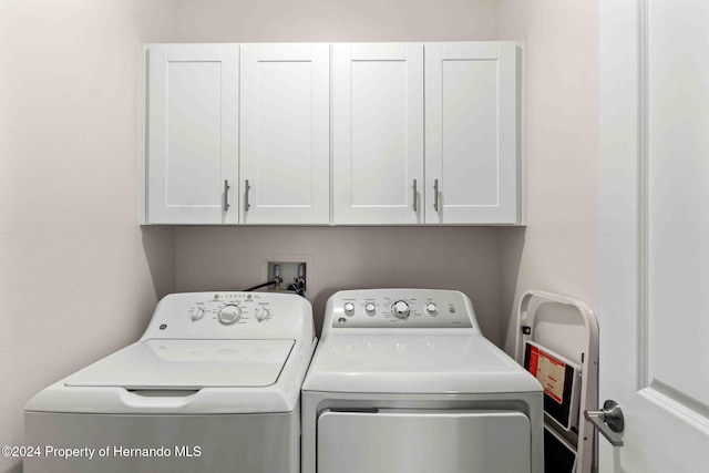 laundry room with washer and dryer and cabinets