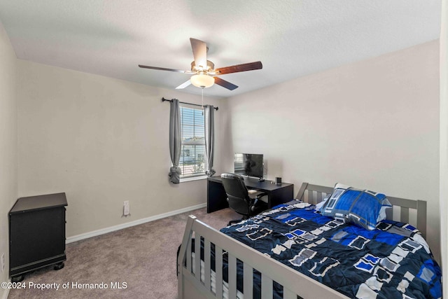 carpeted bedroom with a textured ceiling and ceiling fan