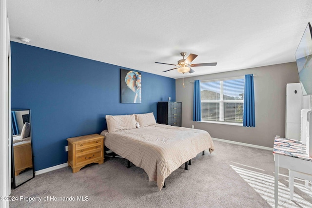 carpeted bedroom with ceiling fan and a textured ceiling