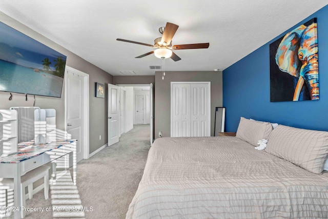 bedroom featuring light carpet, a closet, and ceiling fan