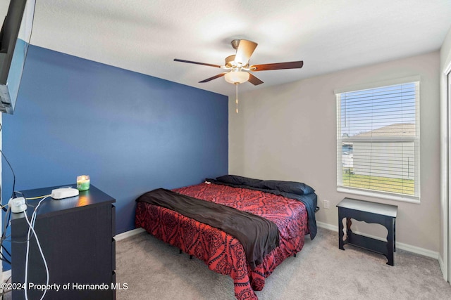 bedroom featuring ceiling fan and light carpet