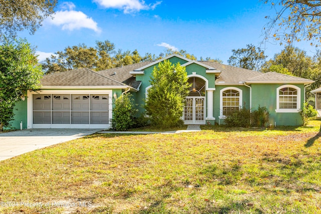 ranch-style house with a front yard, french doors, and a garage