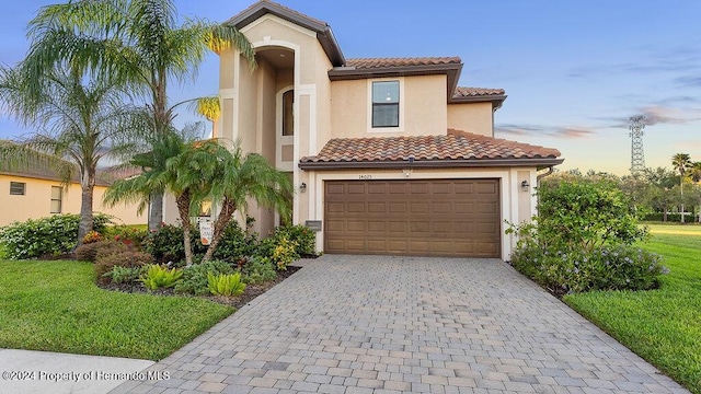 mediterranean / spanish house featuring a yard and a garage