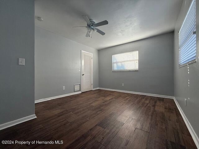 empty room featuring ceiling fan and dark hardwood / wood-style flooring