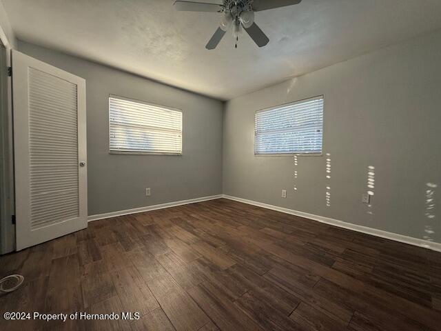 spare room with ceiling fan and dark hardwood / wood-style flooring