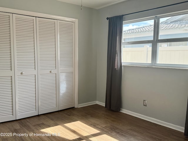 unfurnished bedroom featuring hardwood / wood-style floors and a closet