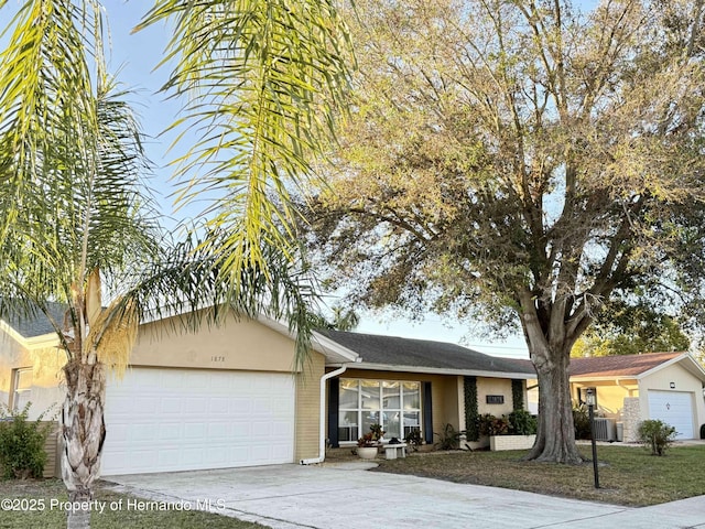 ranch-style home featuring central AC and a garage