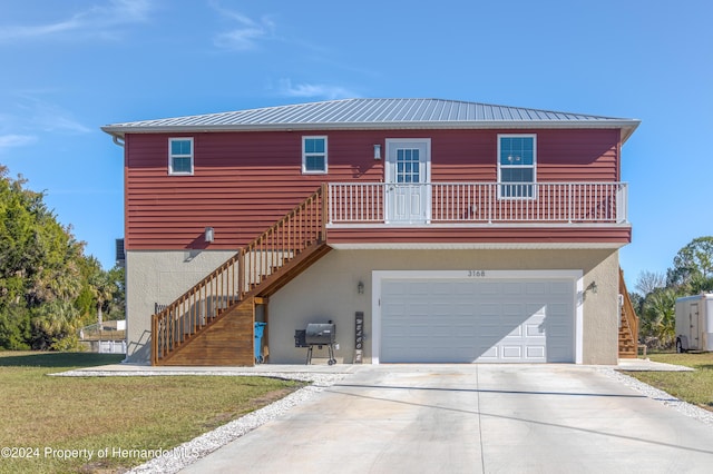 view of front facade with a garage, a balcony, and a front lawn