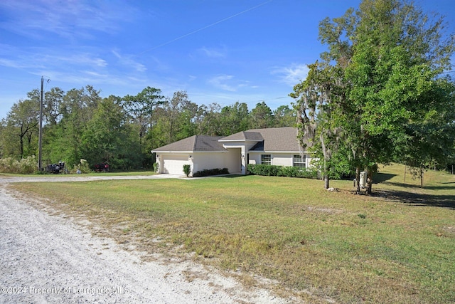 single story home featuring a garage and a front yard