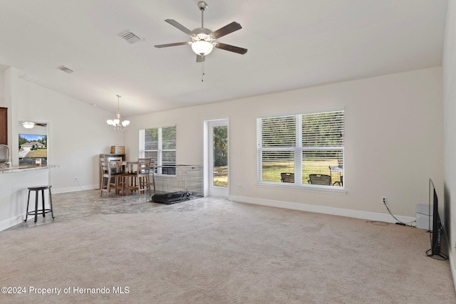 unfurnished living room with light carpet, ceiling fan with notable chandelier, and vaulted ceiling