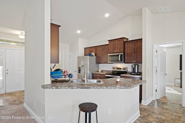 kitchen featuring high vaulted ceiling, a kitchen breakfast bar, sink, kitchen peninsula, and stainless steel appliances