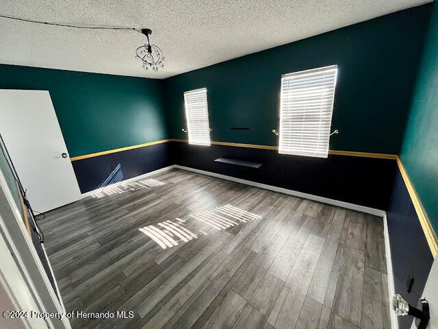 spare room with wood-type flooring and a textured ceiling