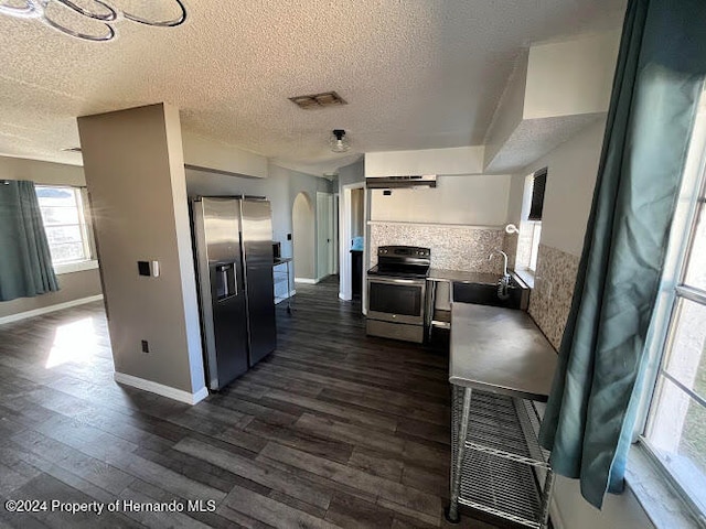 kitchen featuring dark hardwood / wood-style flooring, backsplash, a textured ceiling, stainless steel appliances, and sink