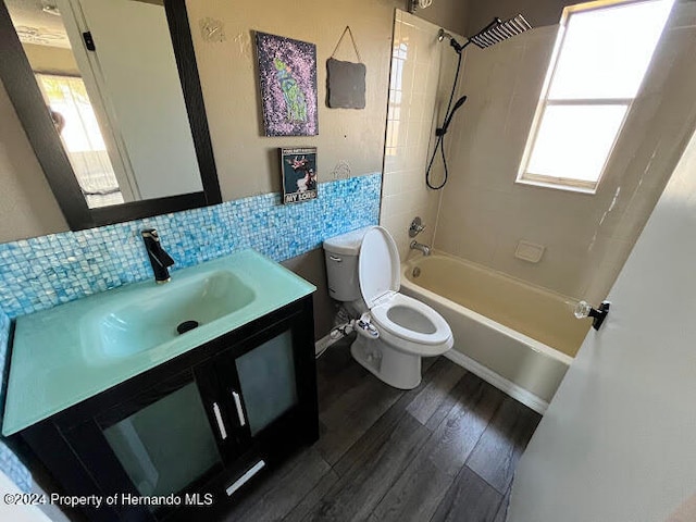 full bathroom featuring tasteful backsplash, hardwood / wood-style floors, a healthy amount of sunlight, and tiled shower / bath combo