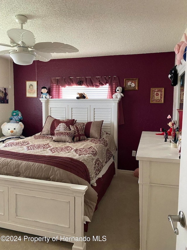 carpeted bedroom featuring a textured ceiling and ceiling fan