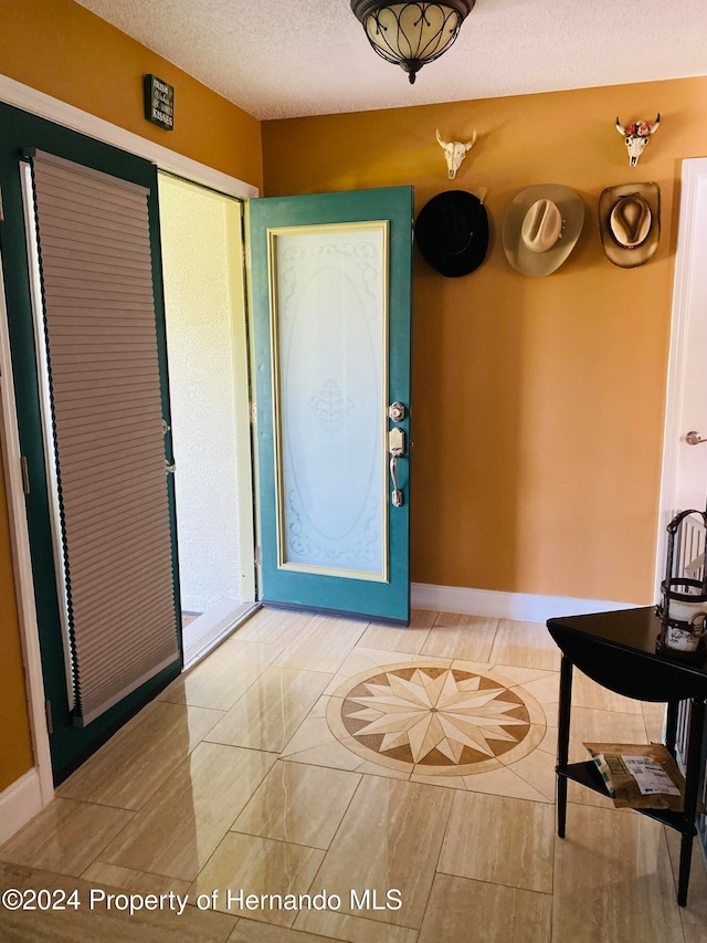 tiled entrance foyer featuring a textured ceiling