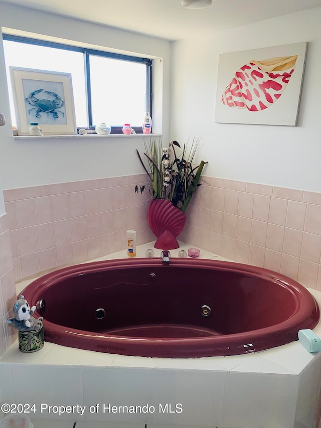 bathroom with a relaxing tiled tub