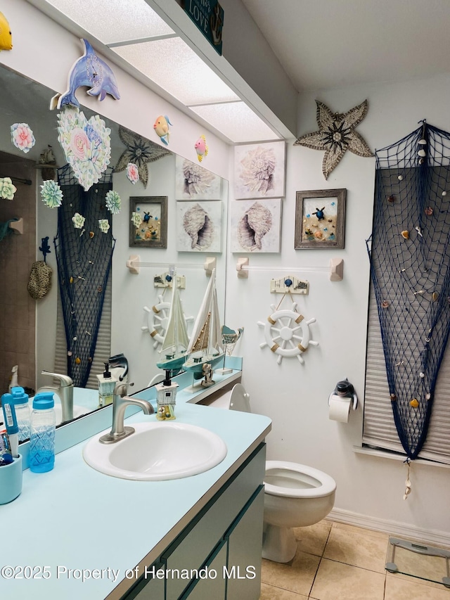 bathroom with toilet, vanity, and tile patterned floors