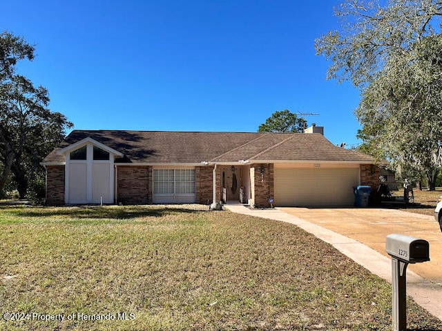 ranch-style home with a garage and a front lawn