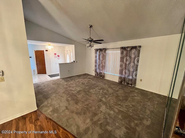 unfurnished living room featuring a textured ceiling, ceiling fan, light hardwood / wood-style flooring, and lofted ceiling