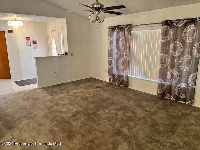 empty room featuring ceiling fan, lofted ceiling, a textured ceiling, and light carpet