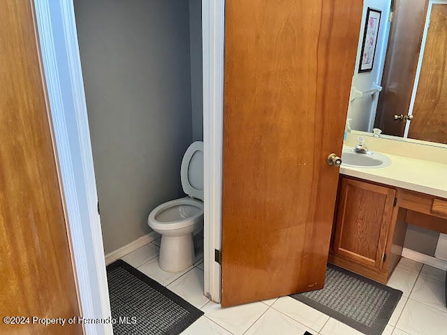 bathroom featuring tile patterned flooring, vanity, and toilet