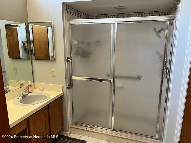 bathroom featuring tile patterned floors, vanity, and an enclosed shower