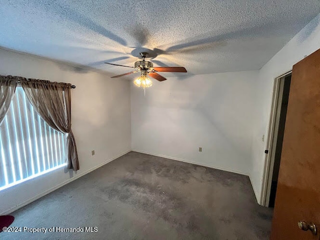 carpeted empty room featuring a textured ceiling and ceiling fan