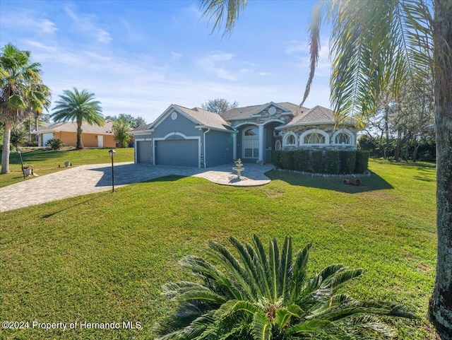 single story home featuring a garage and a front yard