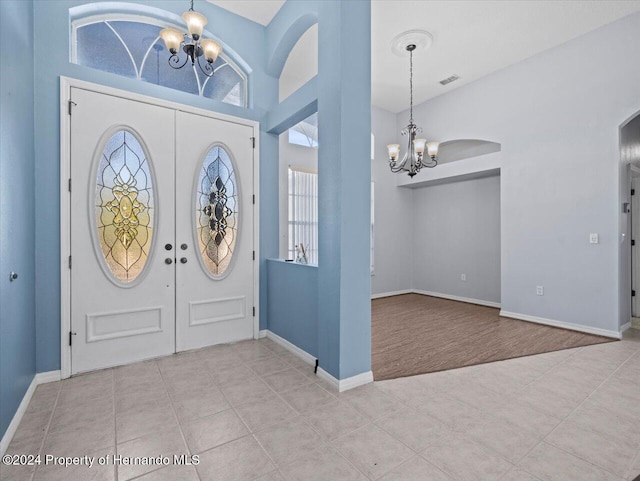 carpeted foyer entrance featuring a notable chandelier