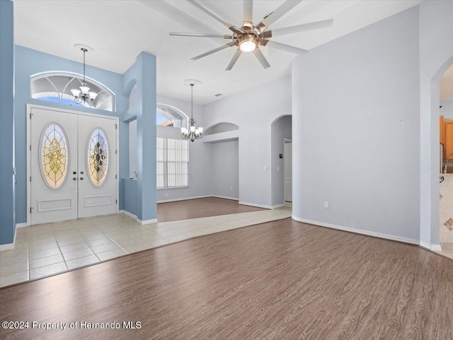 foyer entrance with ceiling fan with notable chandelier and light hardwood / wood-style floors