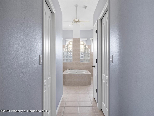 corridor with lofted ceiling and light tile patterned floors