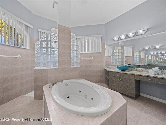 bathroom with plus walk in shower, vanity, and tile patterned floors