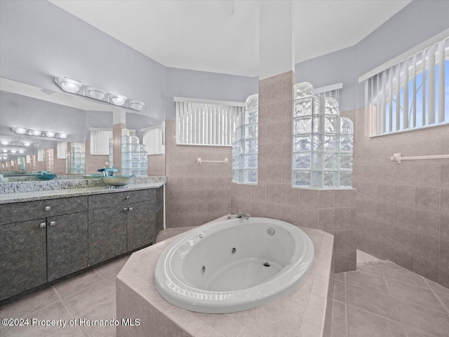 bathroom featuring plus walk in shower, plenty of natural light, vanity, and tile patterned flooring